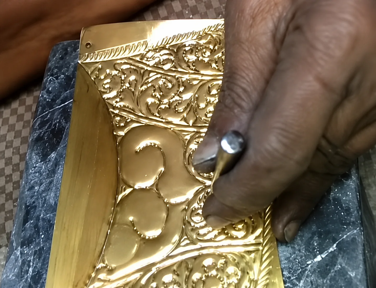 Hand chasing floral details into metal